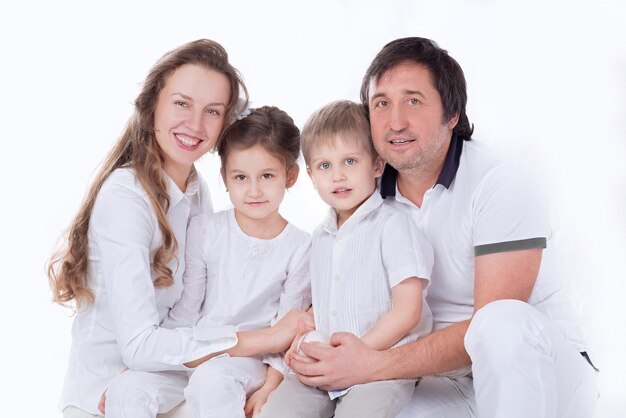 Zdjęcie zamyka w górę szczęśliwej młodej rodziny odizolowywającej na bielu