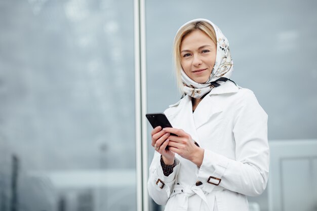 Zamyka w górę widok młodej kobiety w dużym mieście używa telefon