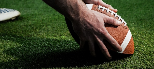 Zamyka w górę widoku futbolu amerykańskiego gracza narządzanie dla kropli kopnięcia