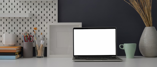 Zamyka w górę widoku ministerstwa spraw wewnętrznych biurko z laptopem, dostawami, dekoracjami i kopii przestrzenią pustego ekranu laptopu