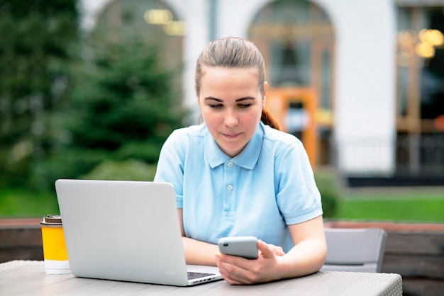 Zamyślona freelancerka pracująca na tarasie w laptopie zdziwiona dziewczyna otrzymała do niej wiadomość sms