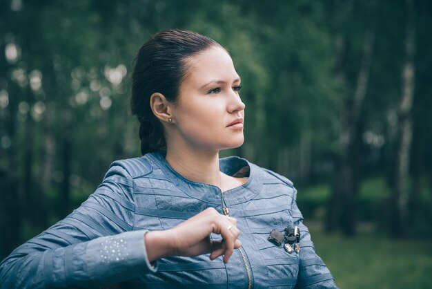 Zdjęcie zamyślona piękna kobieta siedzi na ławce w parku