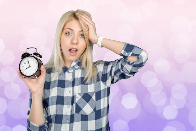 Zdjęcie zaniepokojona młoda kobieta wskazuje na zegarze