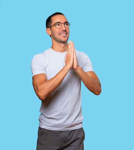 Zaniepokojony młody człowiek modli się gestem