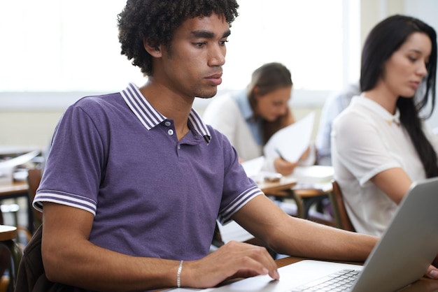 Zanurzony w swoim projekcie Ujęcie grupy studentów pracujących na laptopach w klasie