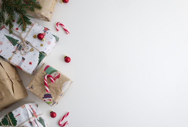 Zdjęcie zapakowane prezenty i dekoracje drzew bożonarodzeniowych z cukierkami umieszczonymi na białym tle