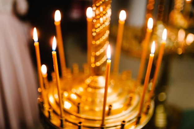 Zapalone świece na świeczniku w kościele. Menora Chanuka z dziewięcioma palącymi się świecami.