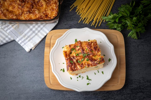 Zapiekanka makaronowa z beszamelowym sosem posypana roztopionym serem mozzarella i podawana w białej naczyniu do zapiekania na stole (turecka nazwa; firinda makarna lub firin makarna)