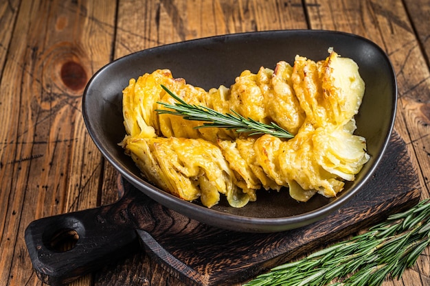 Zapiekanka ziemniaczana Gratin w talerzu z ziołami. drewniane tła. Widok z góry.