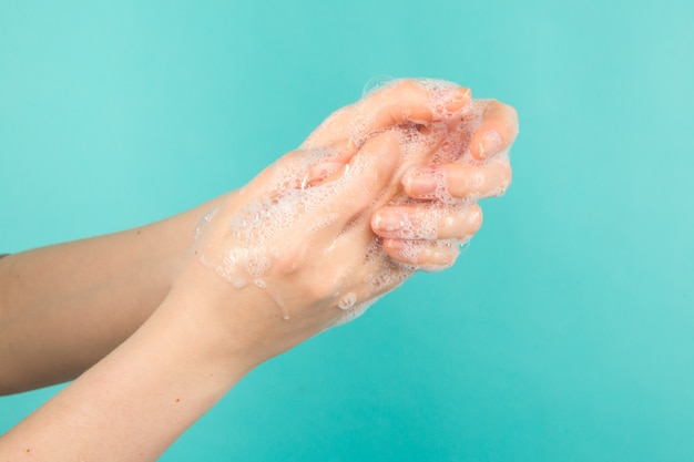 Zapobieganie koronawirusowi. Zbliżenie osoby mycie rąk na białym tle. Koncepcja czystości i pielęgnacji ciała.