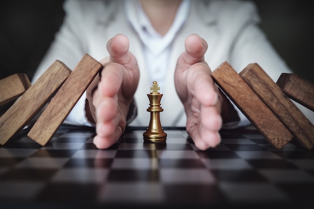 Zdjęcie zapobieganie ryzyku gry w szachy na planszy biznesowej, pojęcie ubezpieczenia biznesowego.