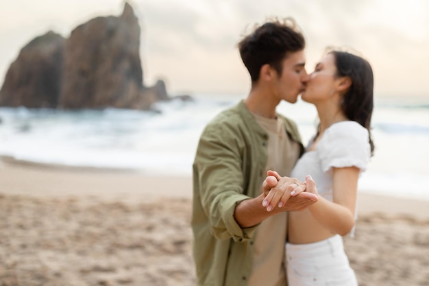 Zaręczona kochająca para ciesząca się romantycznym dniem zaręczyn na plaży, tańcząc i całując się