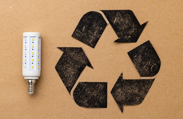 Zdjęcie Żarówka led z symbolem recyklingu na papierze rzemieślniczym