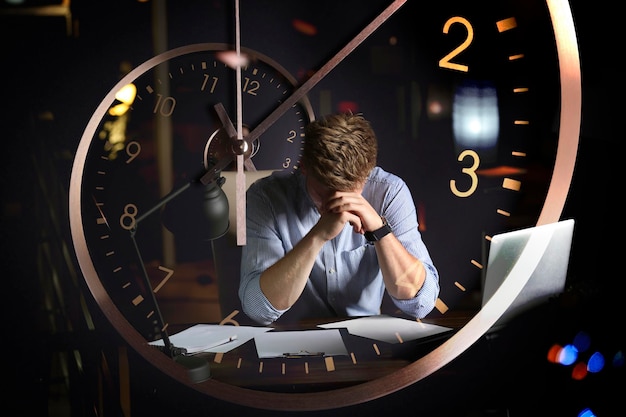 Zarządzanie terminami Podwójna ekspozycja człowieka pracującego w biurze w nocy i na zegarze