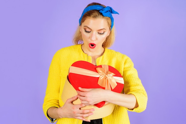 Zdjęcie zaskoczona kobieta z pudełkiem z czerwonym sercem