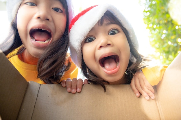 Zaskoczone dzieci rozpakowują świąteczne pudełko na prezent