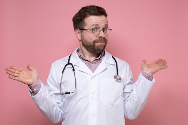 Zaskoczony lekarz ze stetoskopem na szyi niewinnie rozkłada ręce