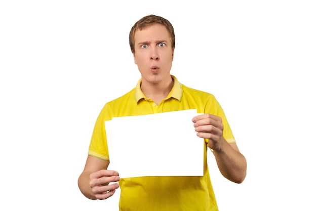 Zdjęcie zaskoczony młody człowiek trzyma makieta papieru arkusz pustego papieru na białym tle