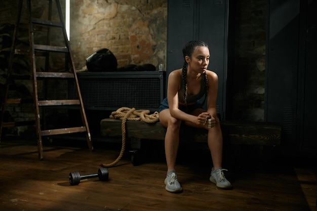 Zastanawiająca się kobieta bokserka na przerwie od ćwiczeń i treningu. Sport, fitness Młoda dziewczyna odpoczywająca po meczu fizycznym wyglądająca na wyczerpaną podczas rutynowego treningu