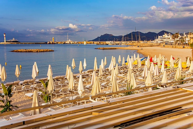 Zatoka morska z jachtami, łodziami i parasolem plażowym w Cannes