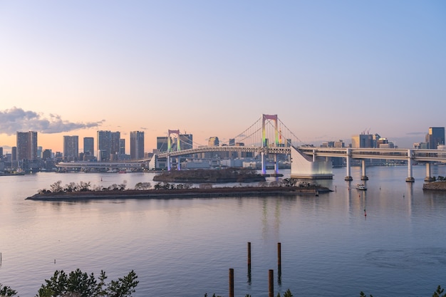 Zdjęcie zatoka tokio o zmierzchu z widokiem na rainbow bridge w mieście tokio, japonia.