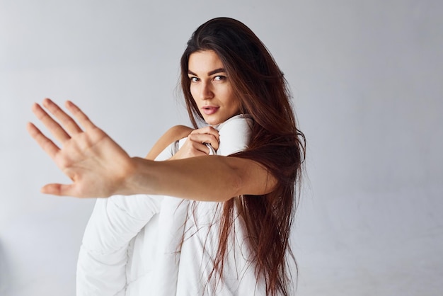 Zdjęcie zatrzymaj gest. kobieta zakrywając ciało ręcznikiem w studio na białym tle.