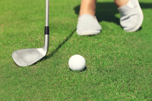 Zawodnik w golfa z kijem zjeżdża piłkę do pucharu na luksusowym polu golfowym