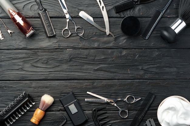 Zawodowe narzędzia fryzjerskie umieszczone na ciemnej drewnianej powierzchni
