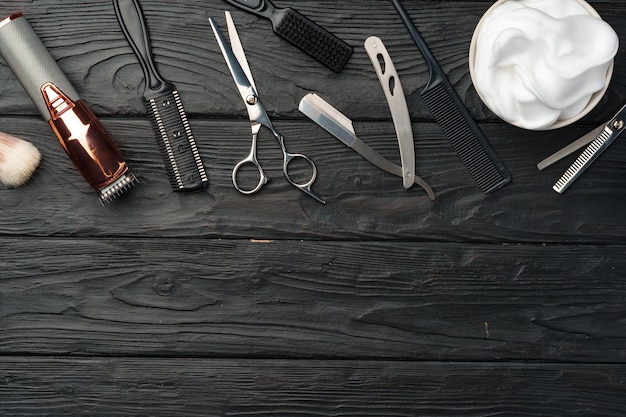 Zawodowe narzędzia fryzjerskie umieszczone na ciemnej drewnianej powierzchni