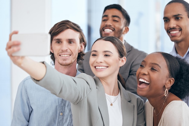 Zawsze jest czas na selfie Zdjęcie przedstawiające grupę biznesmenów robiących selfie w pracy