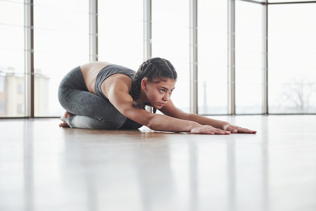 Zawsze trzeba się przygotować. Rozgrzej się na drewnianej podłodze. Młoda dziewczyna fitness przygotowuje się do sesji