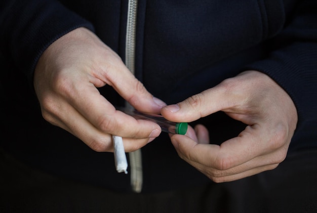 zażywanie narkotyków, nadużywanie substancji, uzależnienie, ludzie i koncepcja palenia - zbliżenie rąk uzależnionych za pomocą stawu marihuany i tępej rurki