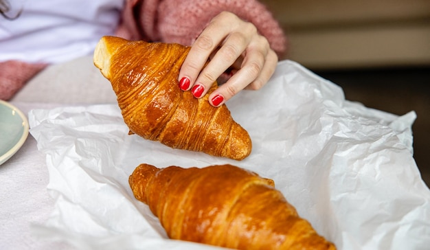 Zbierając ręcznie świeże croissanty z papieru