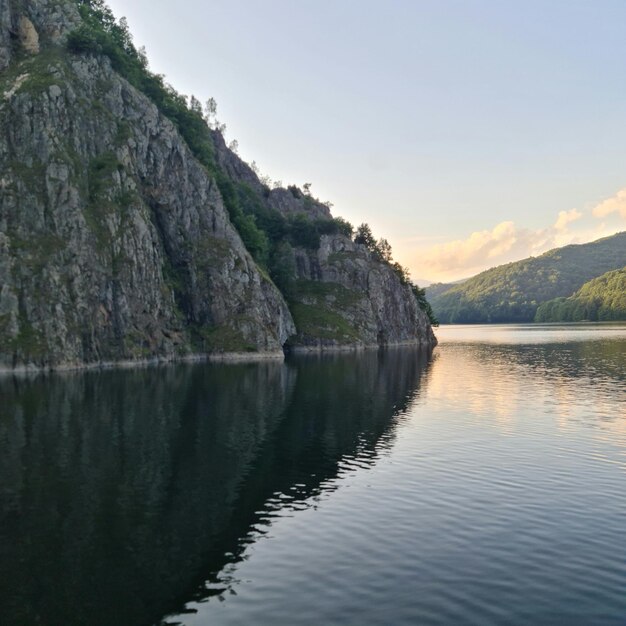 Zbiornik wodny ze skalistym urwiskiem i drzewami