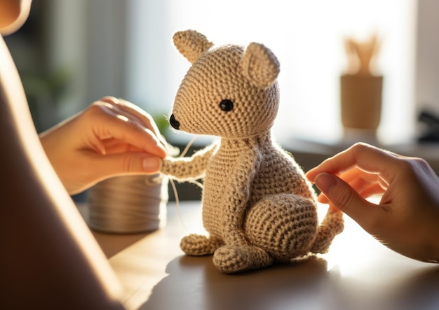 Zbliżający się ujęcie rąk osoby szyjącej realistyczne zwierzęce amigurumi z naciskiem na