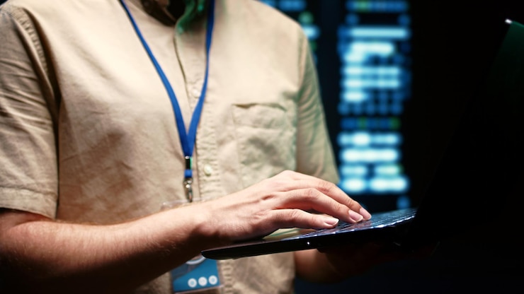 Zdjęcie zbliżenie administratora systemu za pomocą laptopa do sprawdzania operacyjnych klastrów serwerów. montaże w stojakach w centrum danych bezpieczeństwa sieci komputerowej, zapewniające zasoby przetwarzania i pamięci dla kilku obciążeń