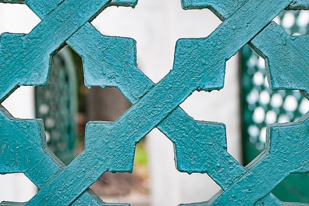 Zbliżenie antycznej drewnianej siatki bramy niebieskiej z pękniętą farbą