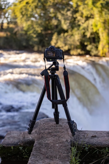 zbliżenie aparatu fotograficznego na statywie, aby sfotografować wodospad selektywnej ostrości