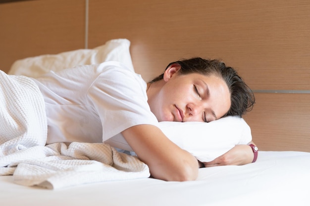 Zbliżenie atrakcyjnej młodej kobiety śpiącej w łóżku w domu Wysokiej jakości zdjęcie