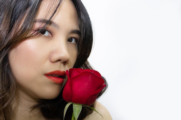 Zbliżenie Azjatka piękna kobieta trzyma czerwoną różę obok ust Walentynki i miłość