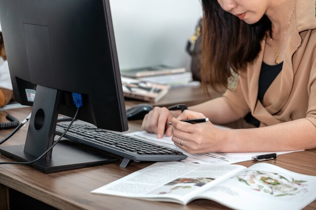 Zbliżenie Azjatycki bizneswoman pisze w formalnym kostiumu i pracuje z komputerem w biurze, biznesie i technologii miejscu pracy