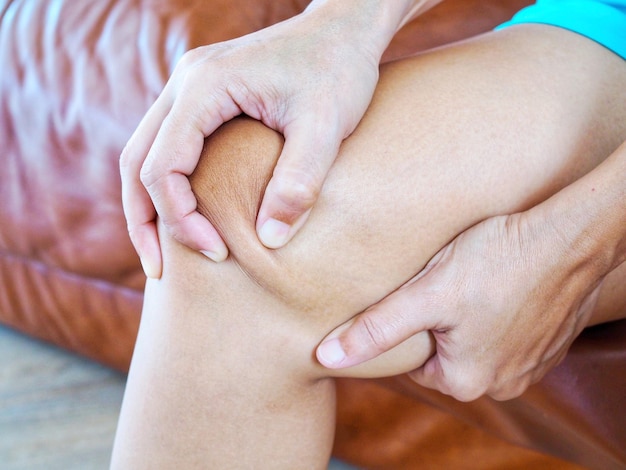 Zbliżenie azjatyckich kobiet z bólem kolan i masażem nóg, aby złagodzić bóle