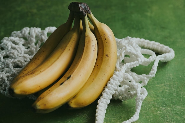 Zbliżenie bananów w torbie na zielonym tle
