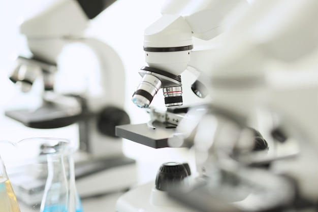 Zbliżenie białych mikroskopów stojących w rzędzie w sprzęcie laboratoryjnym do badań medycznych