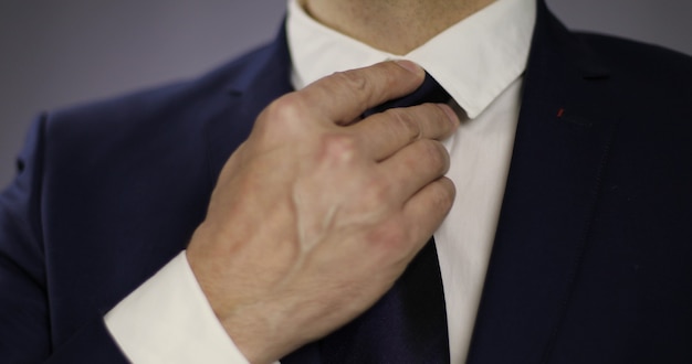Zbliżenie biznesmen w marynarce dopasowując krawat Stylowy mężczyzna w garniturze