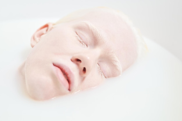 Zbliżenie bladej twarzy młodej spokojnej lub śpiącej kobiety albinos