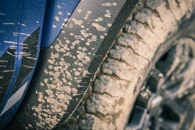 Zdjęcie zbliżenie błotnistego koła dużej opony pojazdu off-road z błotnymi rozpryskami błota na samochodzie 4x4