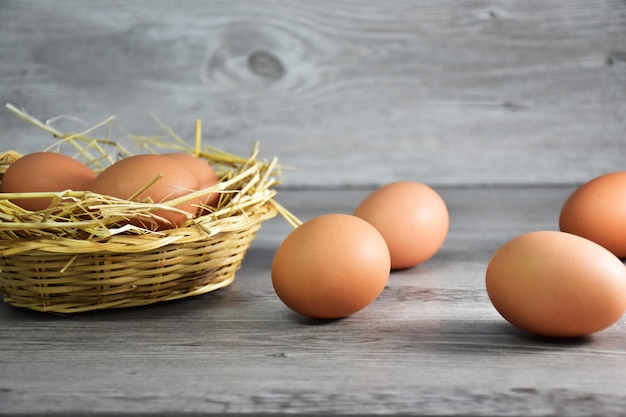 Zbliżenie brown kurczaków jajka / kurzych jajka w drewnianym koszu z ryżowymi siano i jajkami