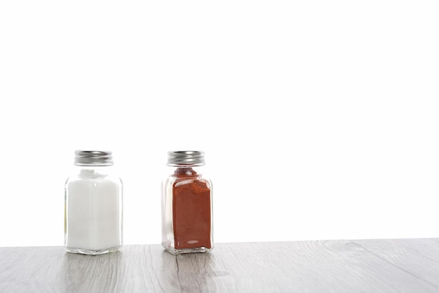 Zbliżenie butelek na białym tle soli i przypraw