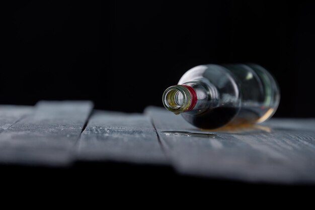 Zdjęcie zbliżenie butelki na stole na czarnym tle